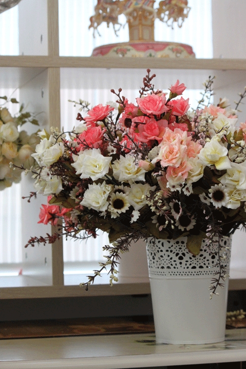 Một chậu hoa đầy màu sắc cạnh giá sách bên cửa sổ Một chậu hoa đầy màu sắc cạnh giá sách bên cửa sổ